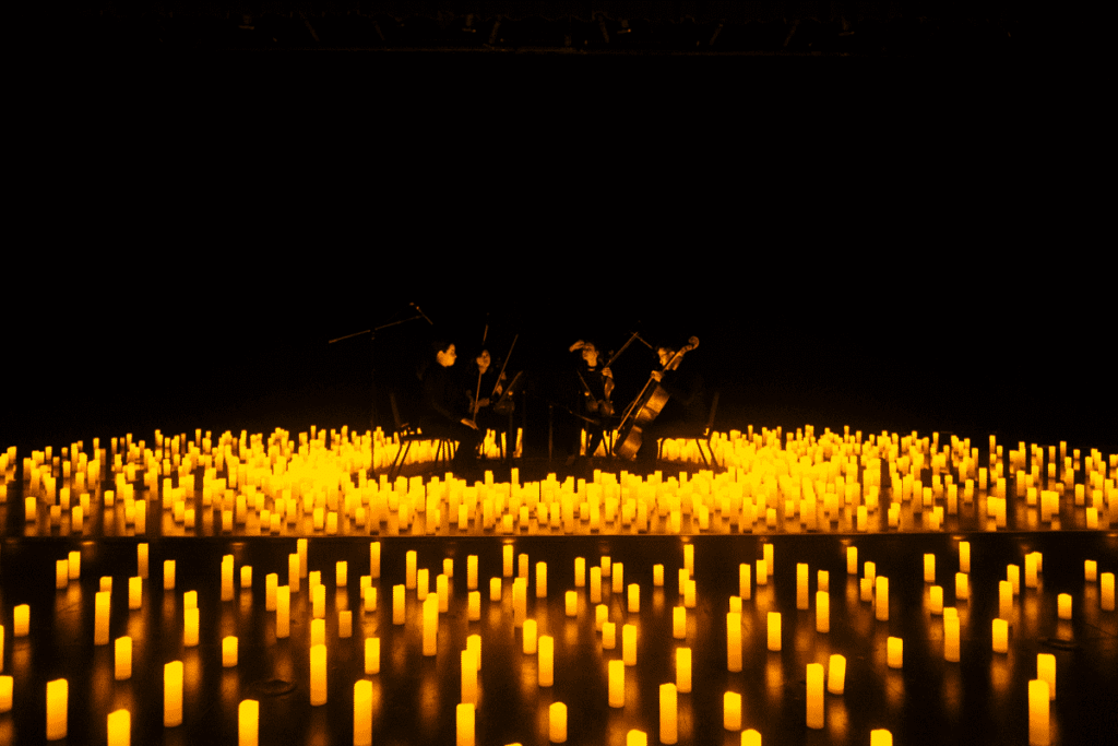 A string quartet take to the stage surrounded by candles