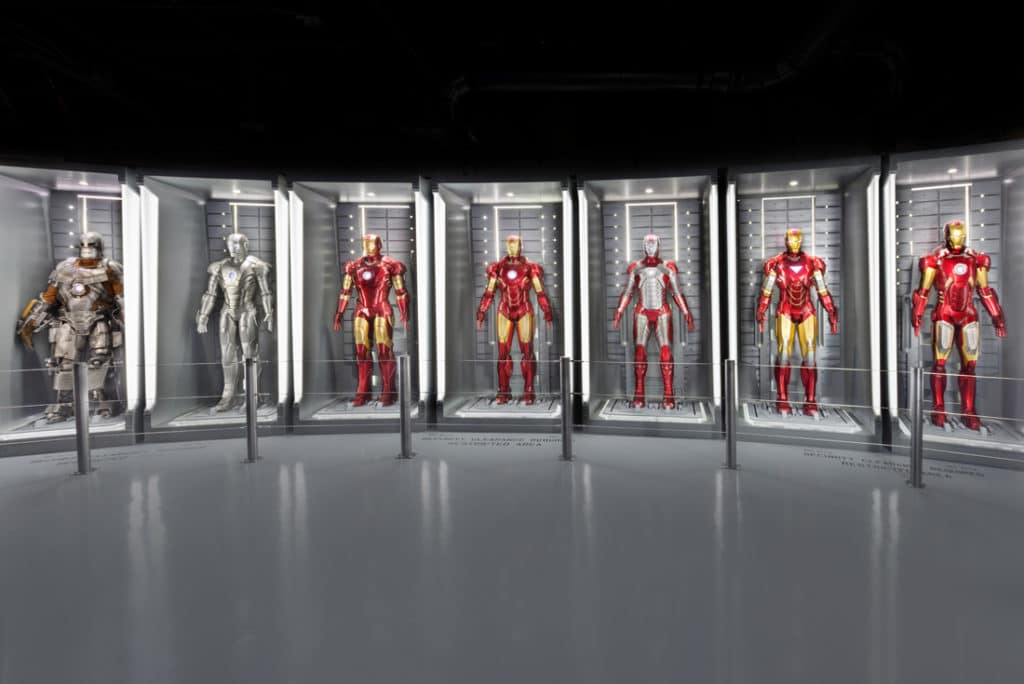 Five Iron man suits behind glass cases at Marvel Avengers Station .