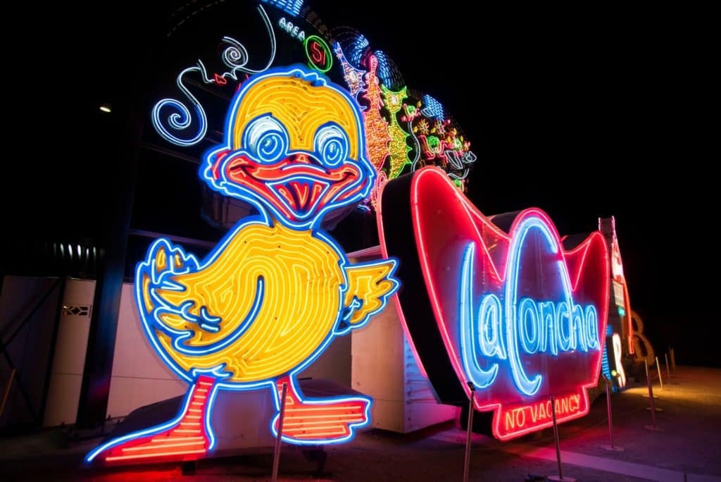 Two neon signs, a duck and a sign that reads 'la concha'.