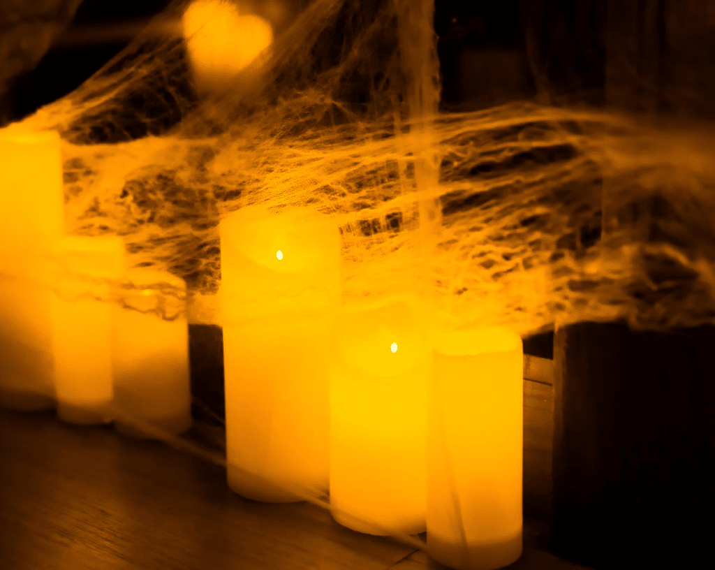A set of candles wrapped in a spider web