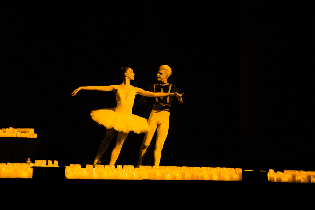 Two ballet dancers performing amid a sea of candles