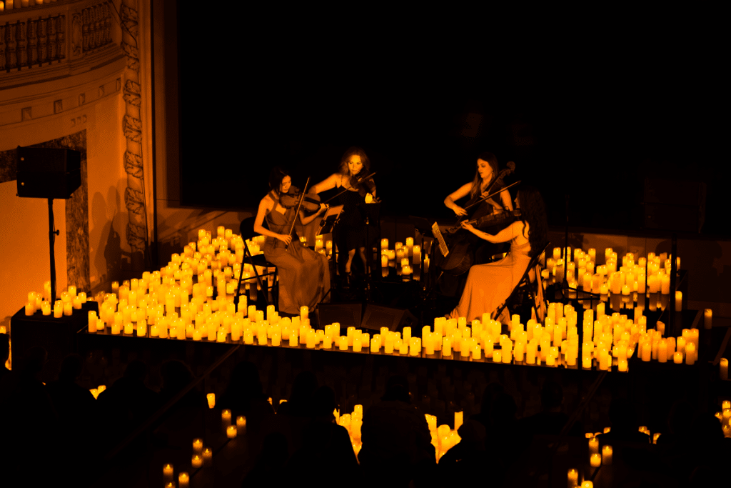 A string quartet performing amid a sea of candles