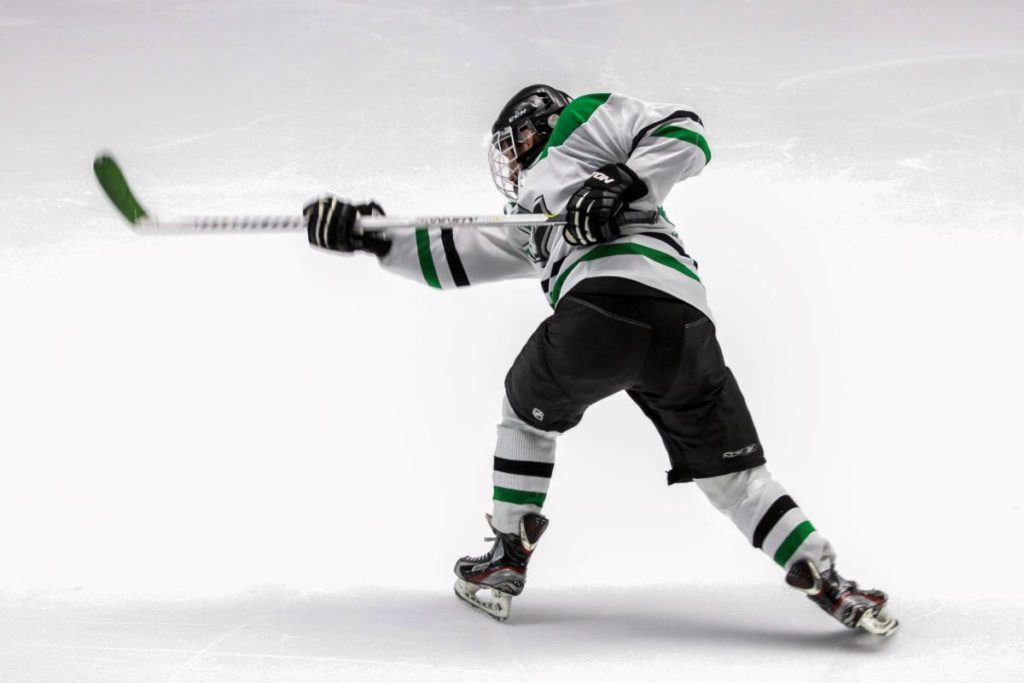An ice hockey player shooting.