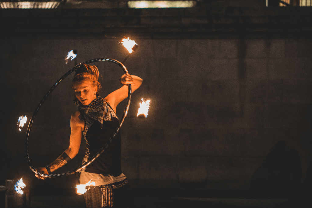 An acrobat performing with a hula hoop on fire