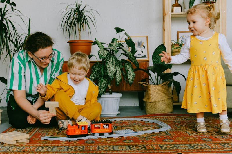 kids and an adult playing with a toy train